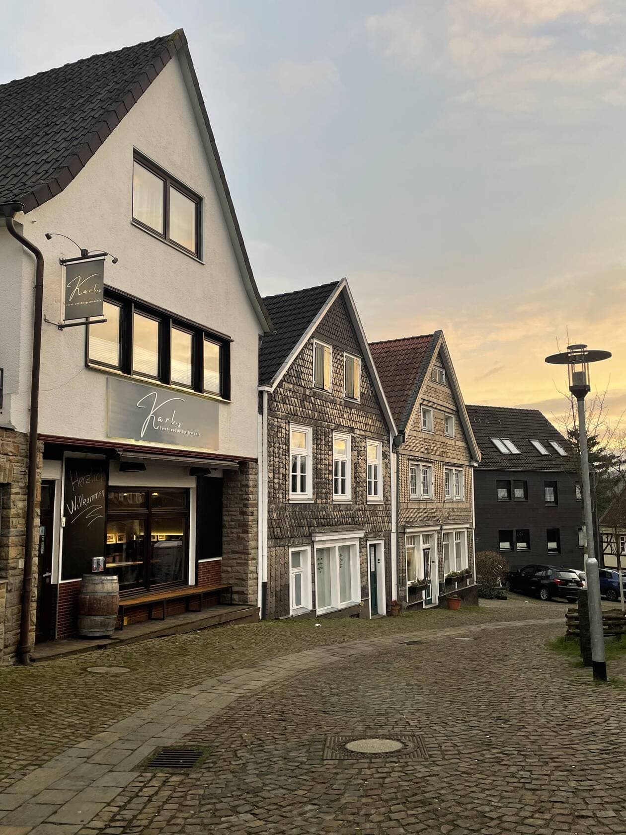 Ladenfront von Karl.s in der Kettwiger Altstadt am Abend, mit Schild und Willkommensgruß